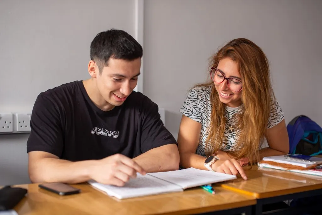 Toplantı odasında dört beş kişilik ekip; masanın başında eğitmen, herkes konuşmanın içinde.